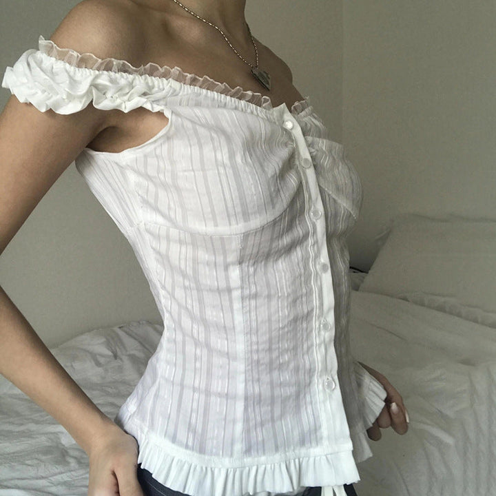 Detaljbilde av hvit off-shoulder damebluse. Fokus på den feminine volangkanten, perfekt for sommerlige antrekk.