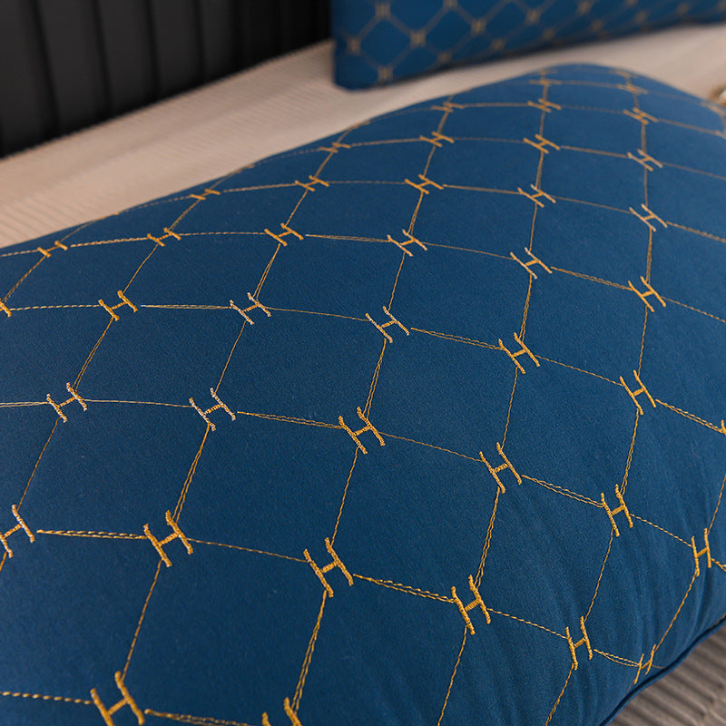 Nærbilde av elegant putetrekk med intrikat brodert geometrisk mønster, gir tekstur til interiørdesign.