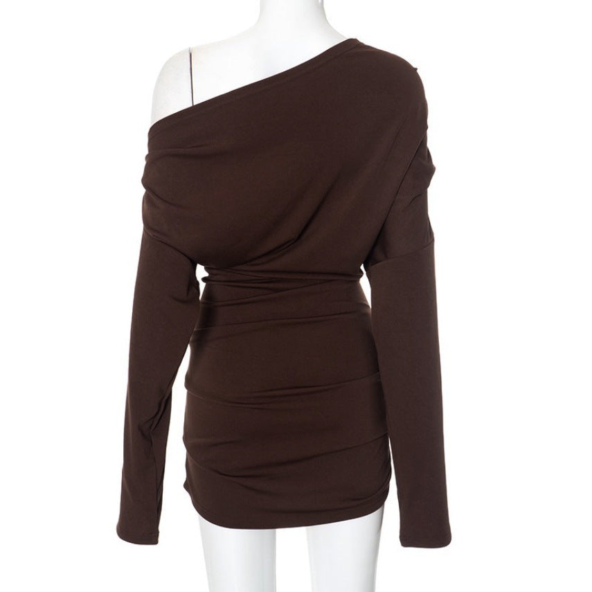 Modern svart langermet dametopp med asymmetrisk hals, draperingsdetaljer og elegant design.