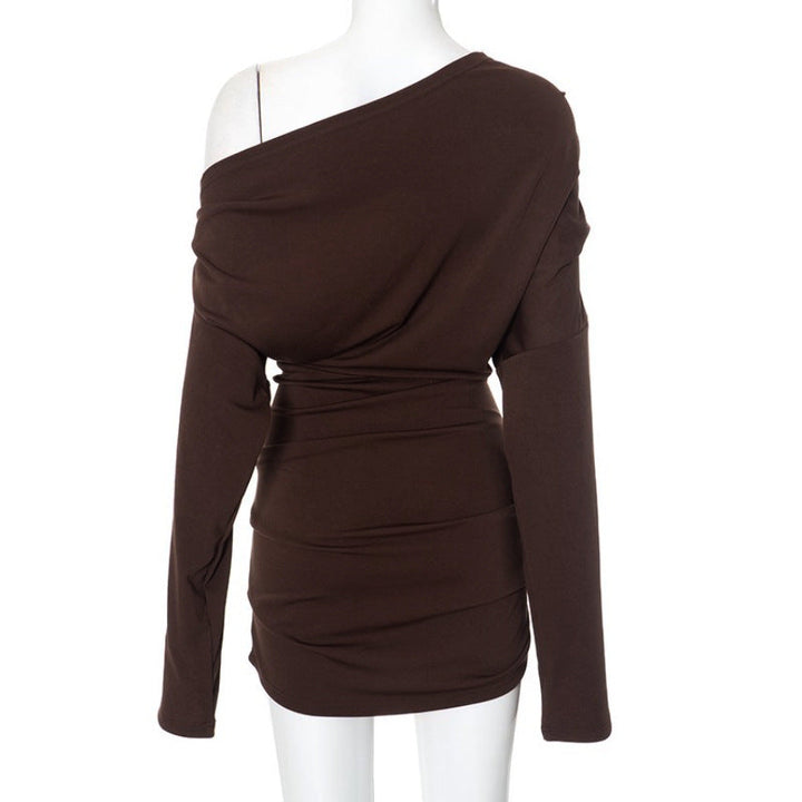 Modern svart langermet dametopp med asymmetrisk hals, draperingsdetaljer og elegant design.