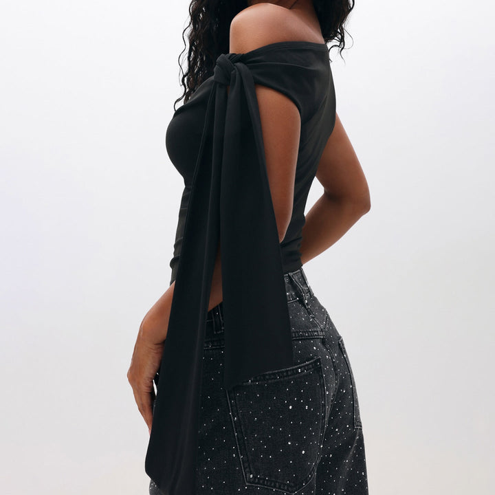 Svart one-shoulder topp dame med elegante steindetaljer. En chic festtopp som passer utmerket til kveldsantrekk.