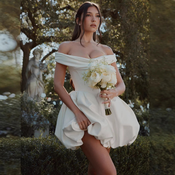 Elegant hvit festkjole med offshoulder design og voluminøst ballkjoleskjørt, ideell for spesielle anledninger.