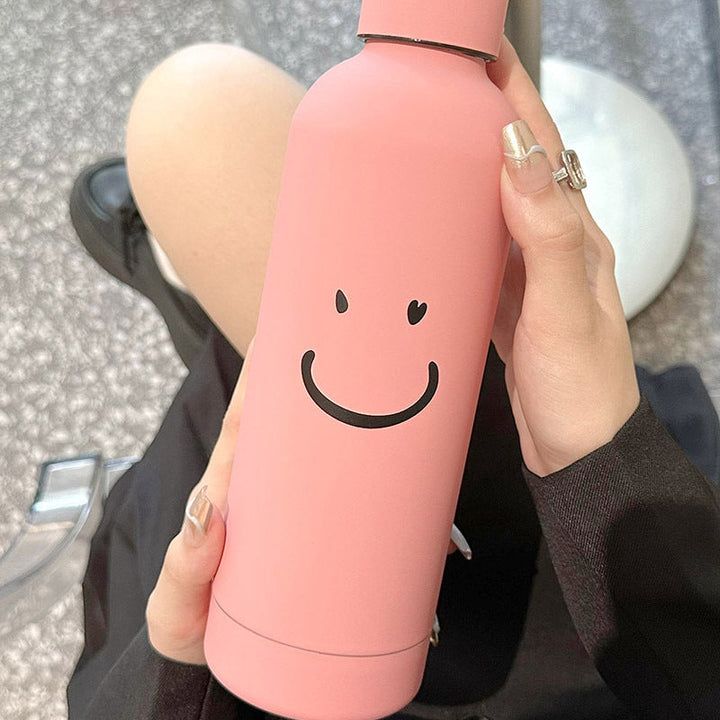 Svart 500ml isolert termoflaske for kvinner. Stilren vannflaske med søtt smilmotiv, perfekt gave.