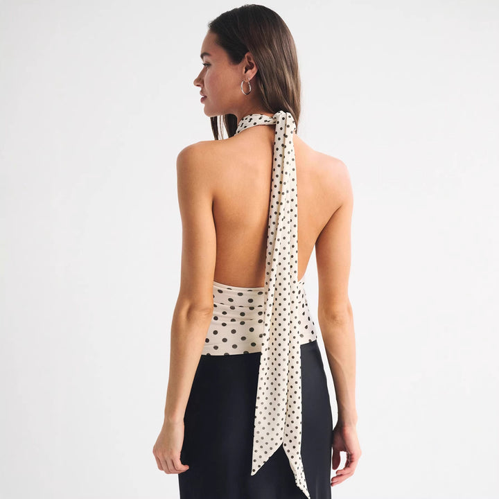 Elegant prikket innpakningsbluse til dame med dyp V-hals. Stilfull topp for både hverdag og festantrekk.