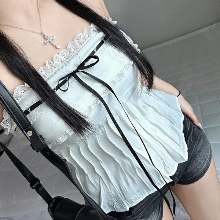 Feminin off-shoulder festtopp i lett stoff med volanger og justerbare bånd, ideell for sommerfest.