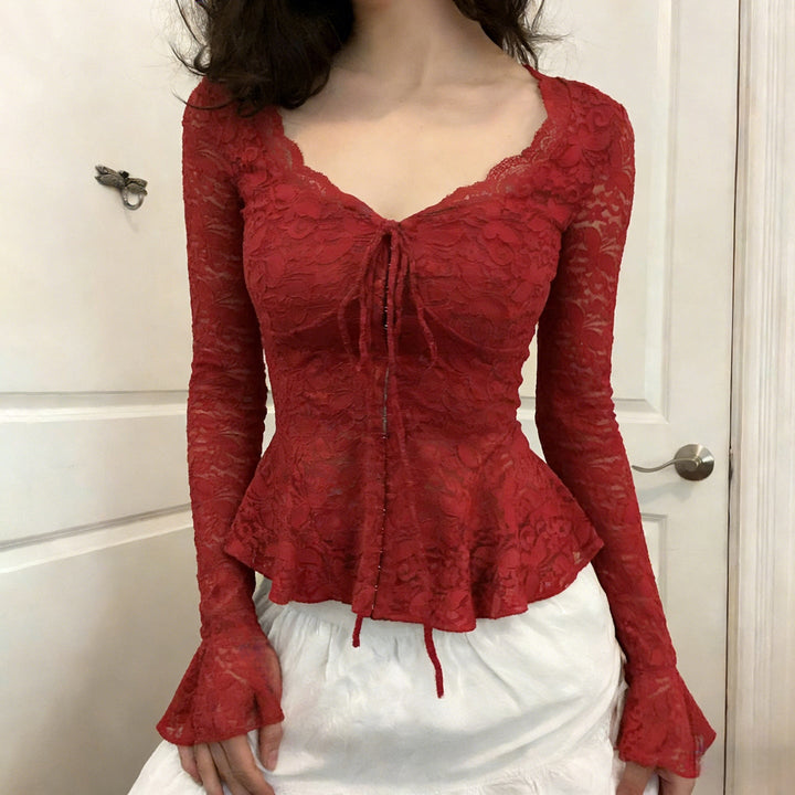 Rød elegant damebluse med romantiske volanger og justerbar knytehals. Perfekt for fest og hverdag.