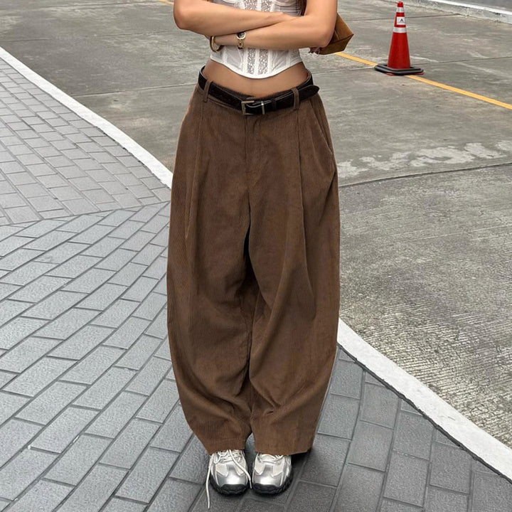 Mørk brune damebukser med høy midje, vide ben og elegante folder. Perfekt for casual eller fest.