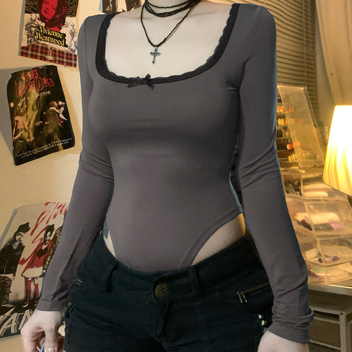 Nærbilde av stoffet på svart langermet damebodysuit, fremhever komfortabelt materiale og kvalitet.