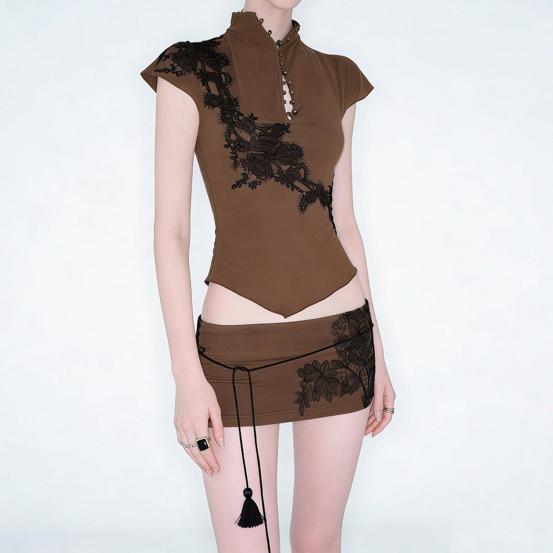 Mote damebluse med intrikate blonder og unike knappedetaljer. Elegant topp for moderne kvinner.