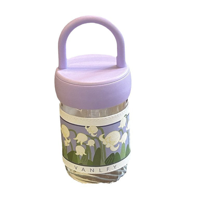 Dame isolert drikkeflaske med lilla blomster, robust design og komfortabelt bærehåndtak.