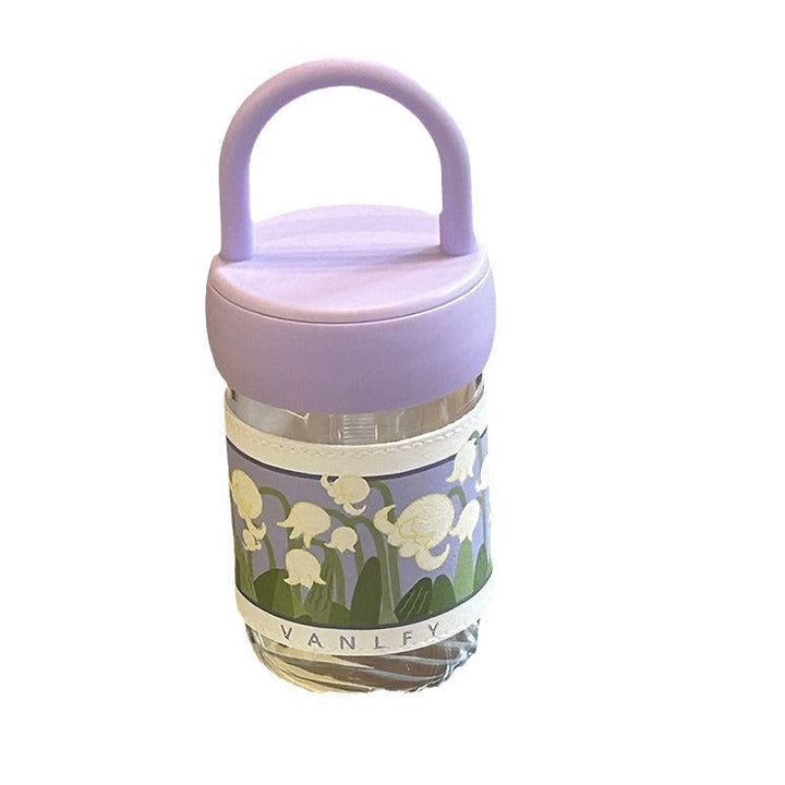 Dame isolert drikkeflaske med lilla blomster, robust design og komfortabelt bærehåndtak.