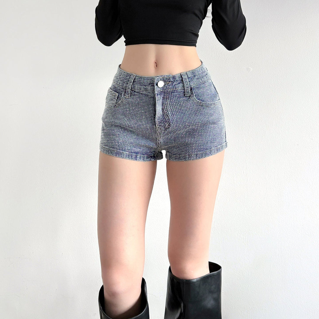Dame iført stilige, glitrende blå denimshorts med høy midje, casual sommershorts for festlige dager.