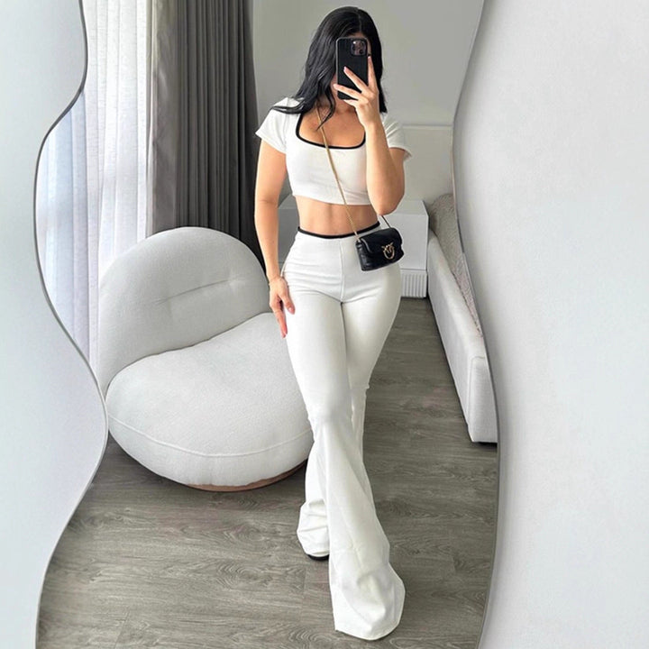 Elegant todelt sett for dame: hvit crop-top og vide bukser. Perfekt sommerstil for motebevisste kvinner.
