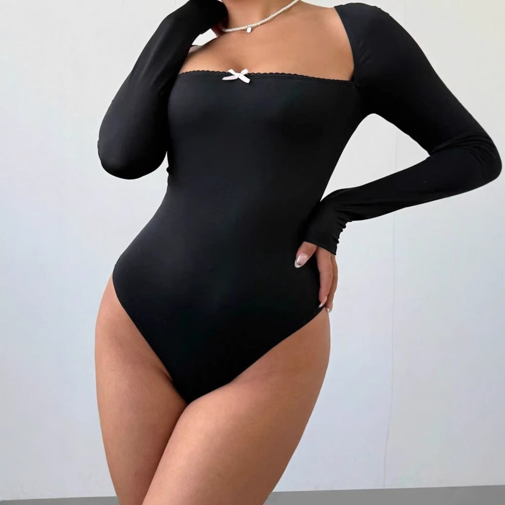 Komfortabel svart langermet bodysuit med flatterende utringning, passer som baseplagg og for spesielle anledninger.