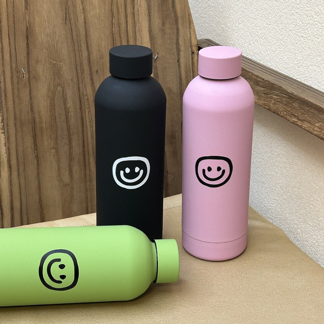 Rosa 500ml vannflaske/termos med smilende ansikt. Robust stålflaske, perfekt for reise.