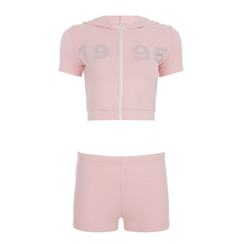 Stilig dame sett med cropped hettegenser og shorts, prydet med glitter. For sporty mote og aktivitet.