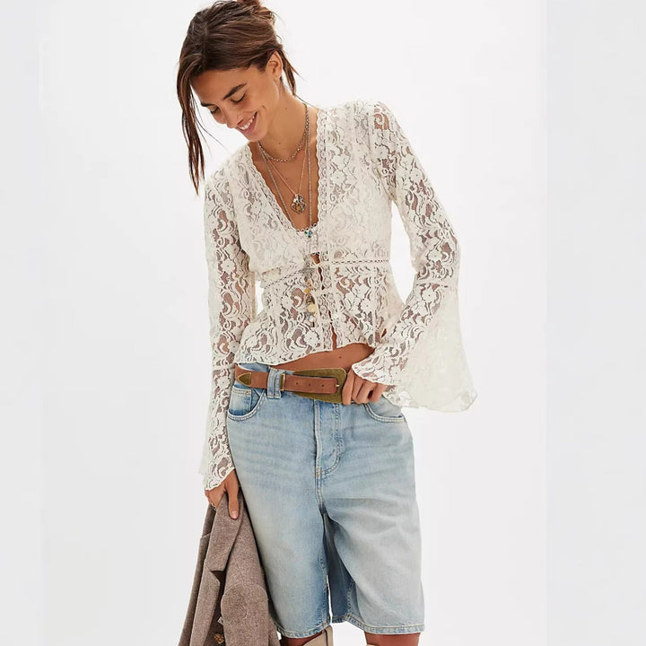 Feminin hvit damebluse i blonde med vide ermer. Romantisk stil, egnet som festtopp eller casual sommerbluse.