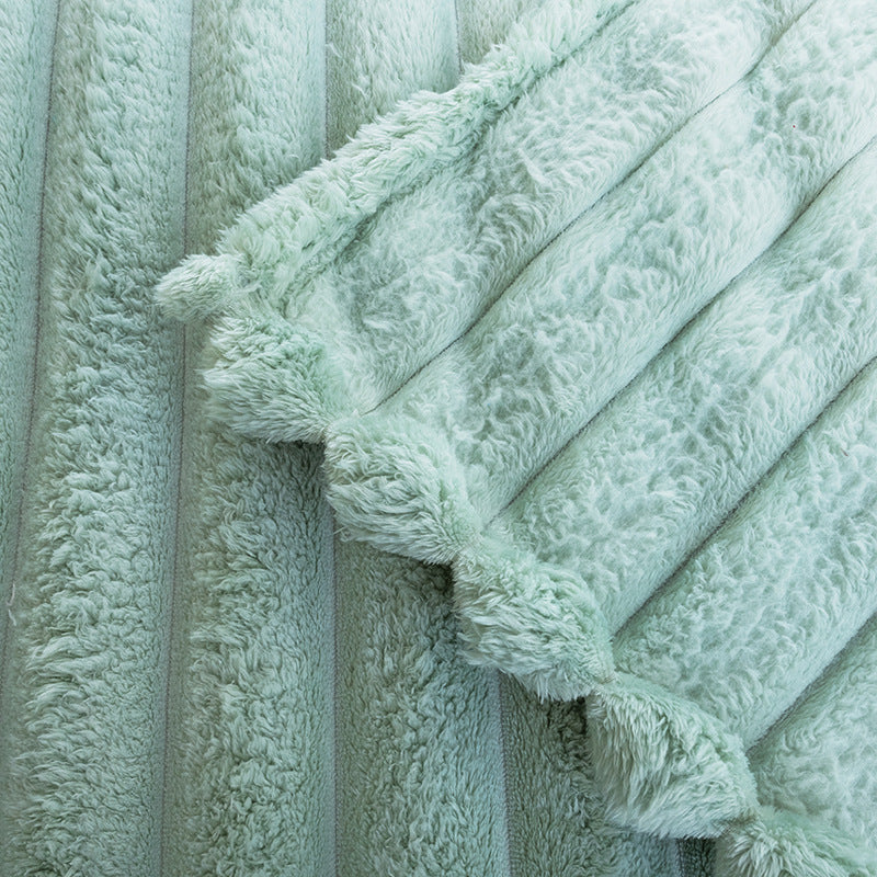 Varmt termo kastepledd i grønn mikrofiber, med elegant bølgestruktur for koselige vinterkvelder.