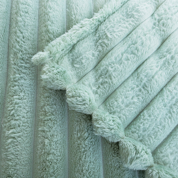 Varmt termo kastepledd i grønn mikrofiber, med elegant bølgestruktur for koselige vinterkvelder.