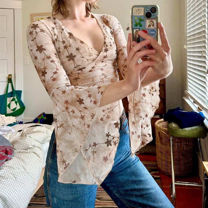 Justerbar innpakningsbluse med v-hals, voluminøse ermer og trendy blomstermønster. Perfekt casual eller festtopp.
