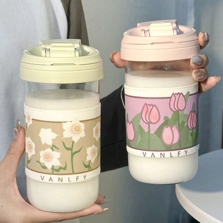 Elegant reisekopp for damer, med rosa og lilla blomstermotiver, perfekt for kaffe eller te.