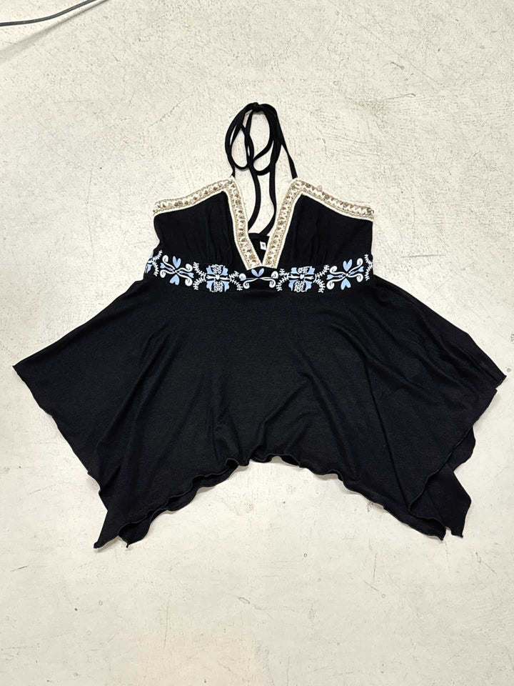 Modell iført elegant omslagsbluse med blonde og V-hals, feminint og luftig design, ideelt for sommer.