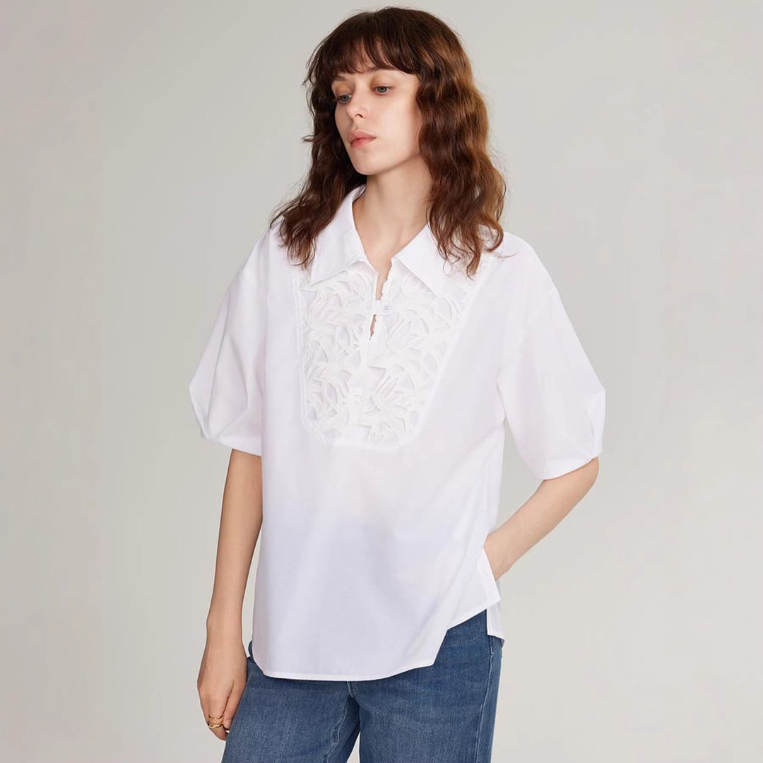 Modell viser elegant hvit sommerbluse med broderi, perfekt som festtopp eller hverdagsskjorte.