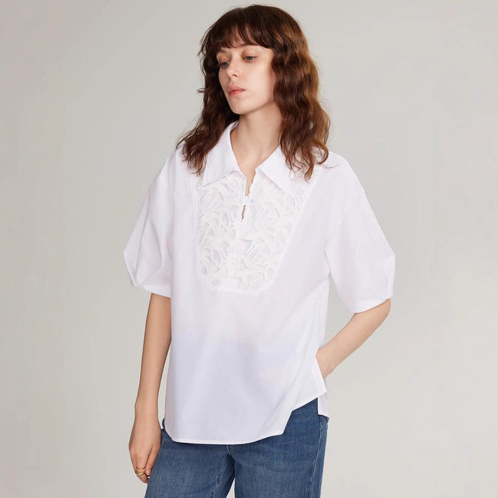 Modell viser elegant hvit sommerbluse med broderi, perfekt som festtopp eller hverdagsskjorte.