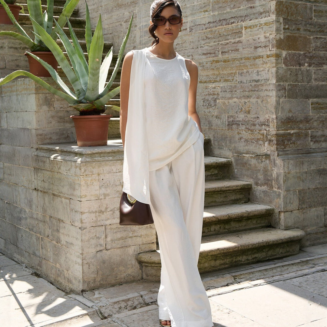 Trendy hvit asymmetrisk festtopp for kvinner, ideell for sommerens sosiale arrangementer.