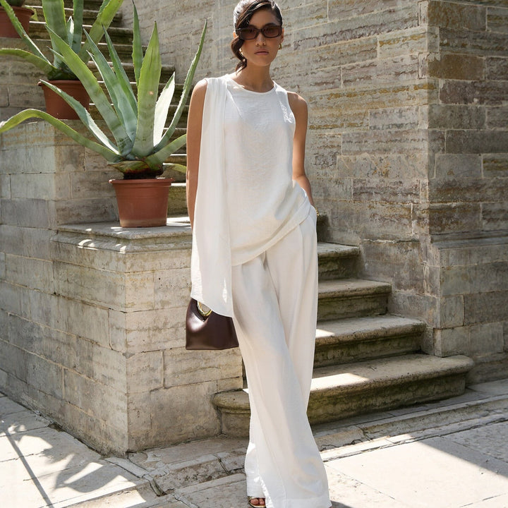 Trendy hvit asymmetrisk festtopp for kvinner, ideell for sommerens sosiale arrangementer.