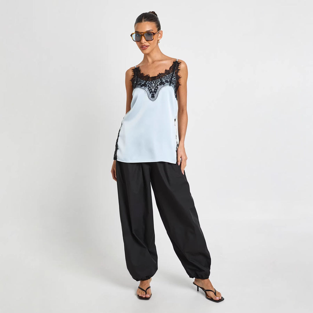 Stilfull blå cami topp for dame med delikate stropper og elegant fall. Ideell vår- og sommerklær for fest eller fritid.