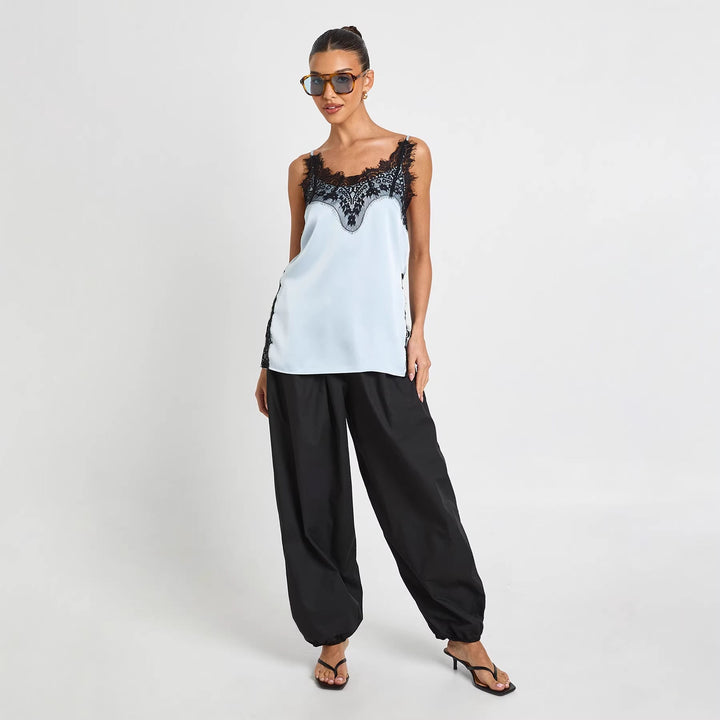 Stilfull blå cami topp for dame med delikate stropper og elegant fall. Ideell vår- og sommerklær for fest eller fritid.