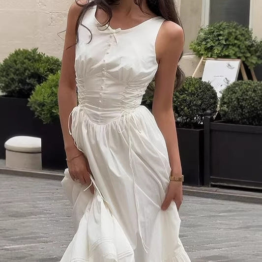 Nærbilde av hvit dame maxikjole, fremhever de delikate volangene og figursydd passform. En elegant sommerkjole.