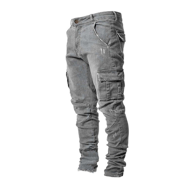 Mann sitter i grå cargo jeans, viser komfortabel slank passform og allsidig stil.