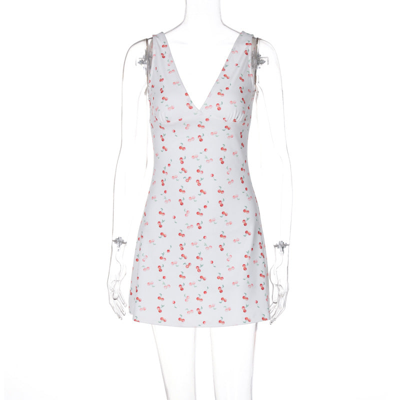 Hvit sommerlig minikjole med trendy kirsebærmønster og dyp V-hals. Perfekt for solrike dager.