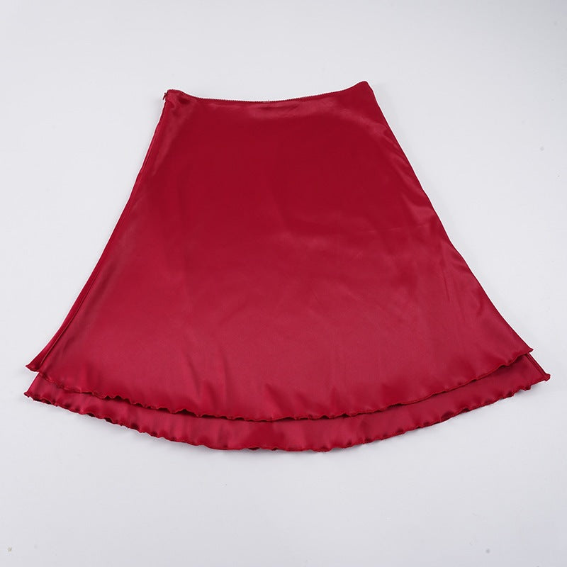 Flytende rødt midi-skjørt med elegante volangdetaljer. Et allsidig dameskjørt for ulike anledninger.