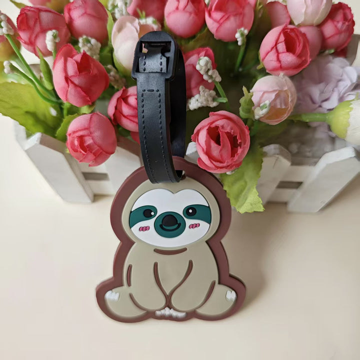 Detaljert bilde av en dovendyr bagasjelapp i myk silikon, klar til å merke kofferten din.