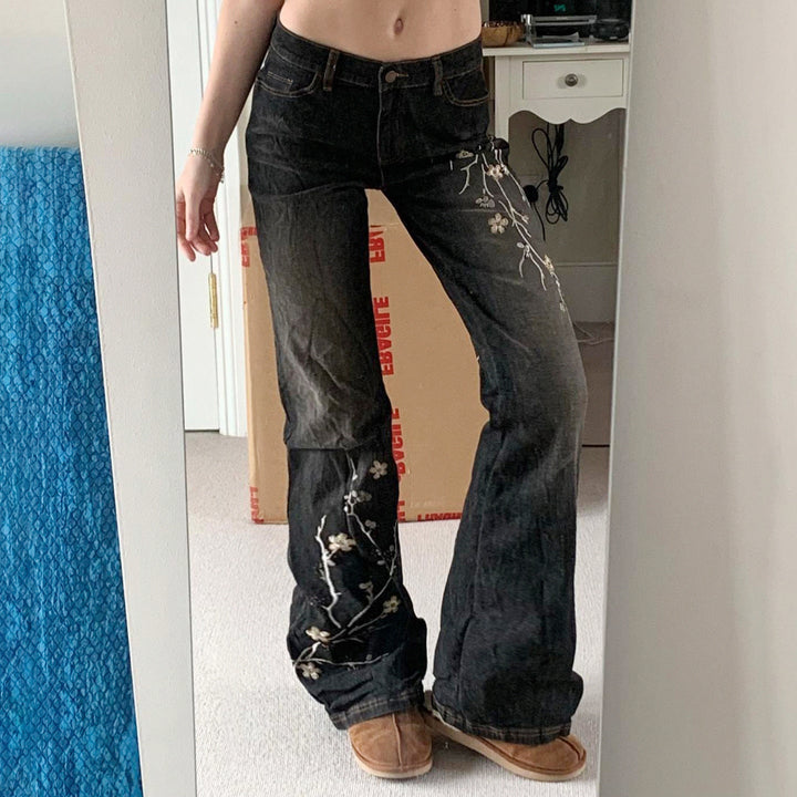 Svarte flared damejeans med høyt liv og brodert blomstermønster, perfekt for moteriktig vår/sommerstil.