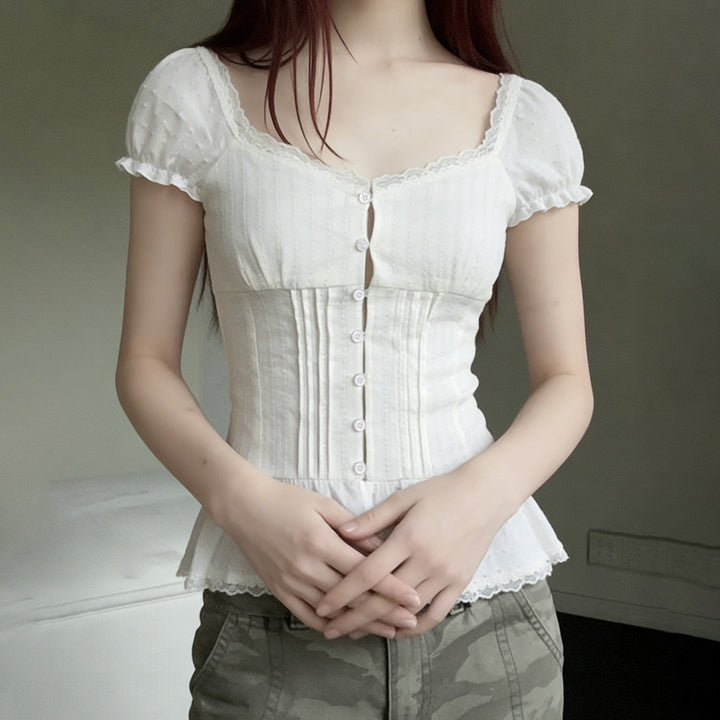 Elegant damebluse med detaljerte volangkant og moteriktige puffermer. Hvit, luftig og stilfull topp.
