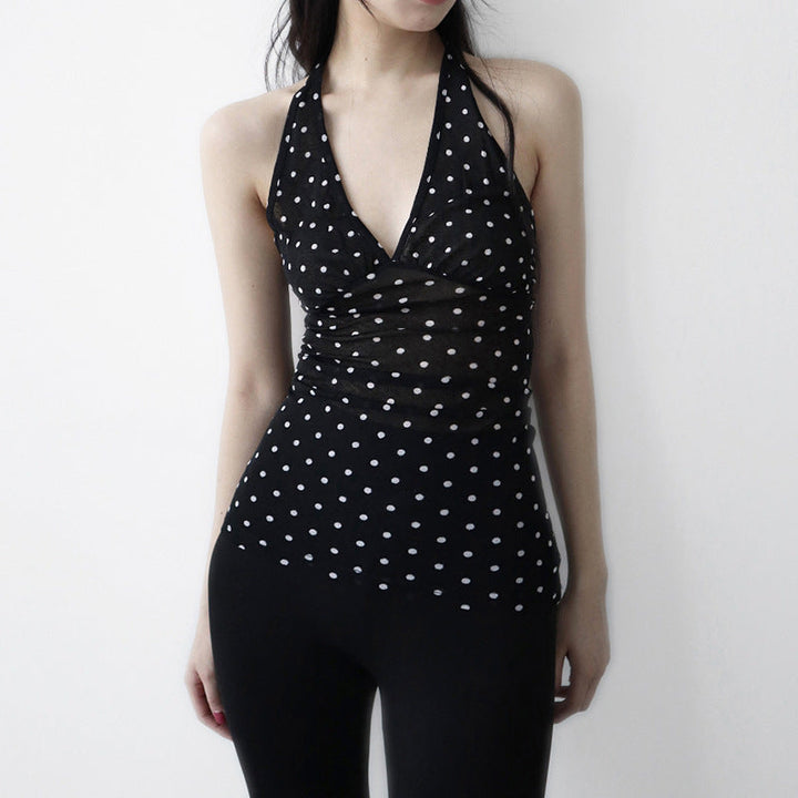 Svart halterneck topp med hvite prikker for sommer og fest. Elegant dame strandtopp i mote.