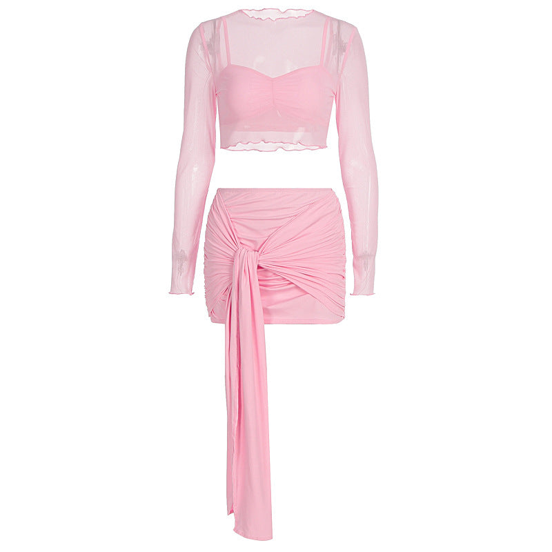 Feminint rosa todelt antrekk; rynket crop top og skjørt, elegant og luftig sommerstil for damer.