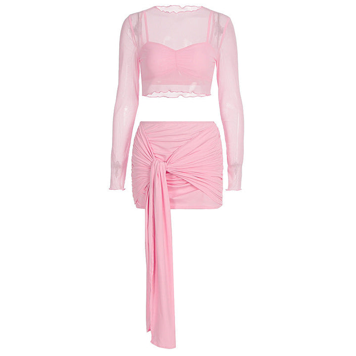 Feminint rosa todelt antrekk; rynket crop top og skjørt, elegant og luftig sommerstil for damer.