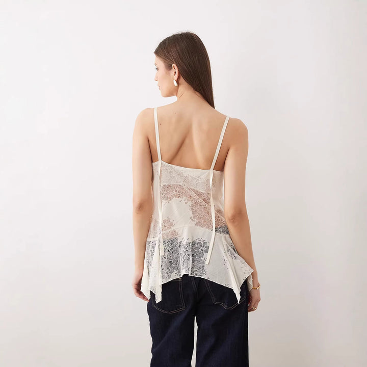 Stilig blondebluse med spaghettistropper og flytende, asymmetrisk passform. Hvit damebluse for sommer og fest.