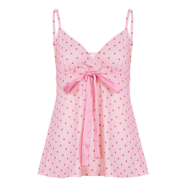 Detaljert bilde av elegant blonde topp for dame, med prikker, svalende stoff og justerbart knytebånd i rosa.