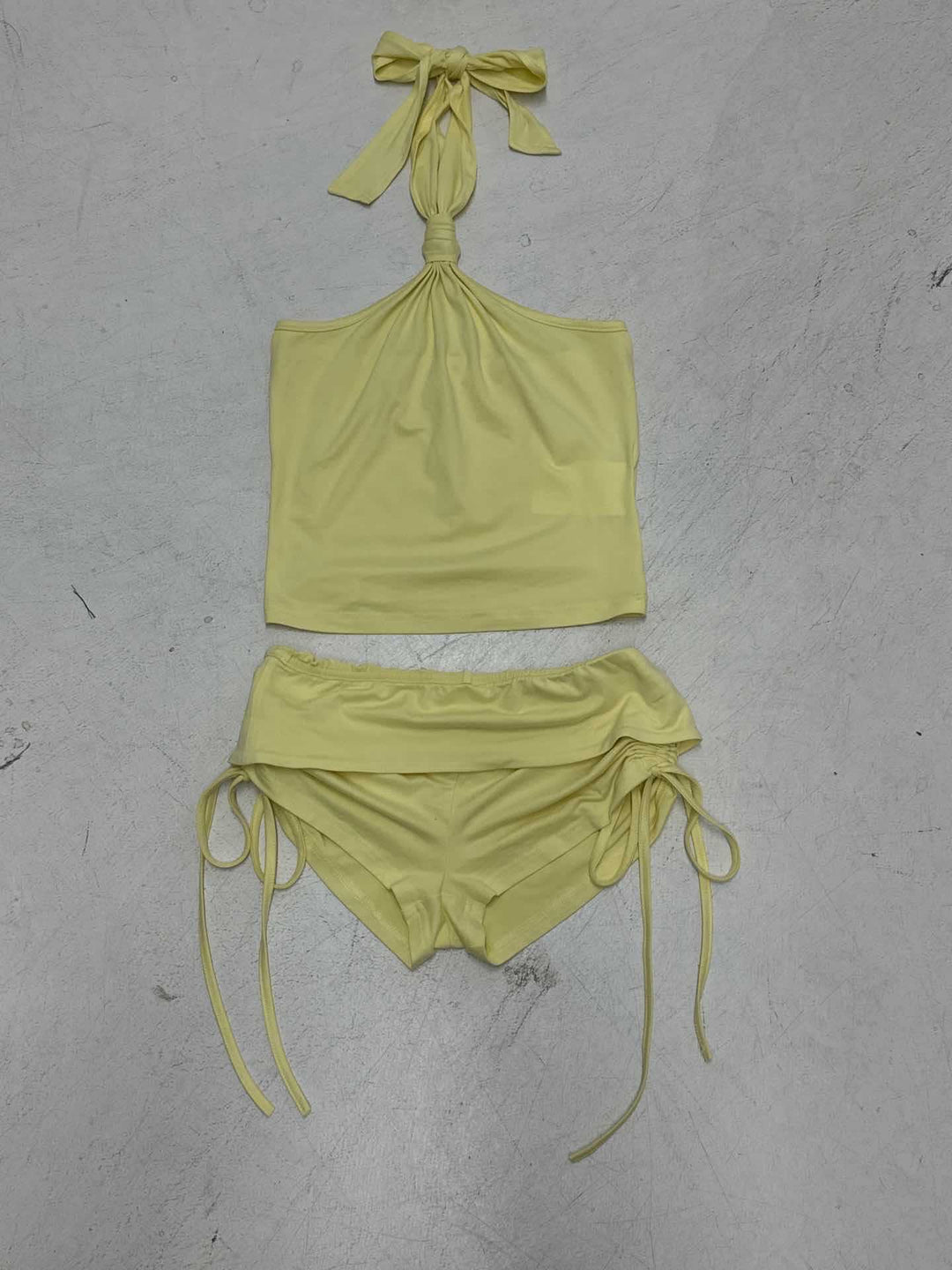 Stilig gul shorts med volanger og snøring, del av et trendy todelt dame badetøy-sett.