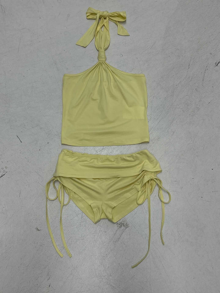 Stilig gul shorts med volanger og snøring, del av et trendy todelt dame badetøy-sett.