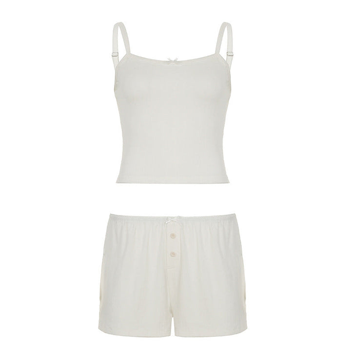 Modell iført elegant dame nattsett med spaghetti-stropper, shorts og knappdetaljer i mykt stoff.