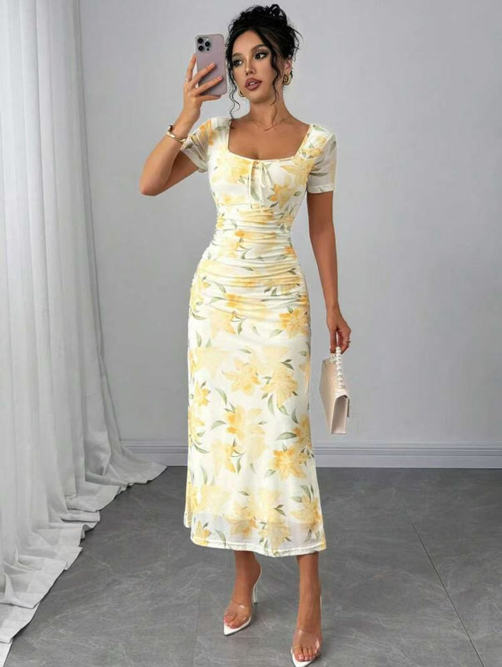 Komfortabel og elegant dame midi-kjole med blomsterprint og folder, perfekt for fritid eller sommerlige festligheter.