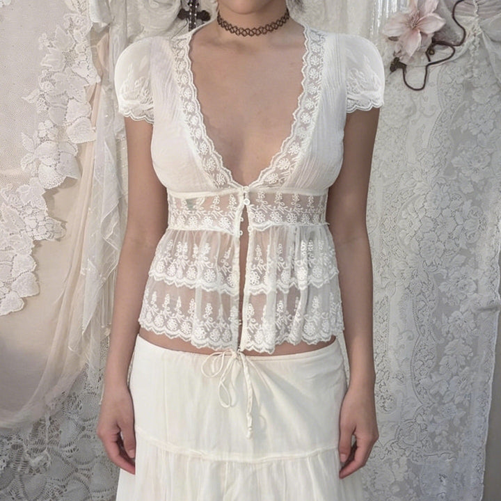 Elegant hvit damebluse med V-hals og volanger. Perfekt for fest eller hverdag.