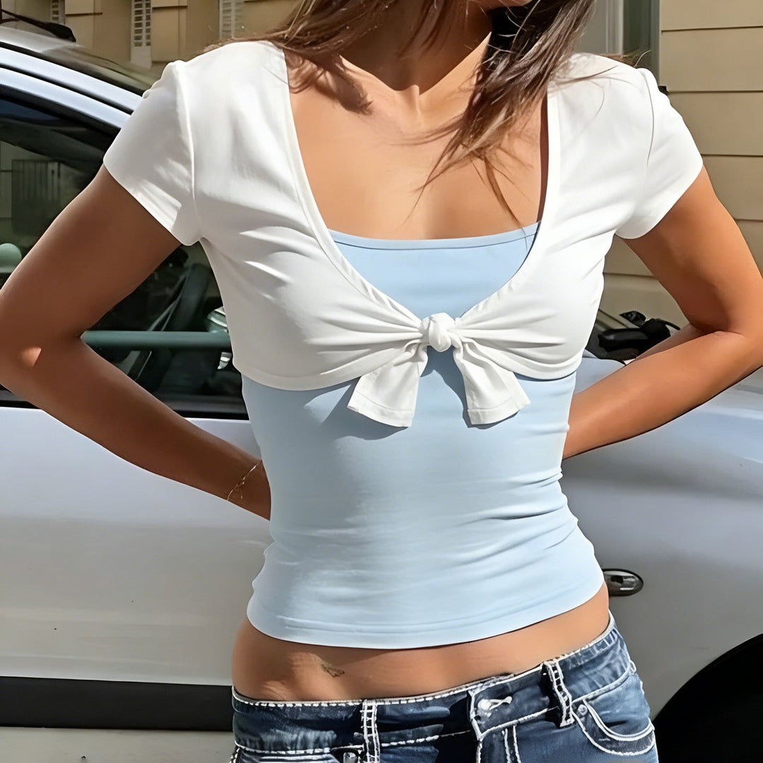Elegant kortermet blusetopp for damer med v-hals og trendy knutedetalj. Perfekt sommertopp.